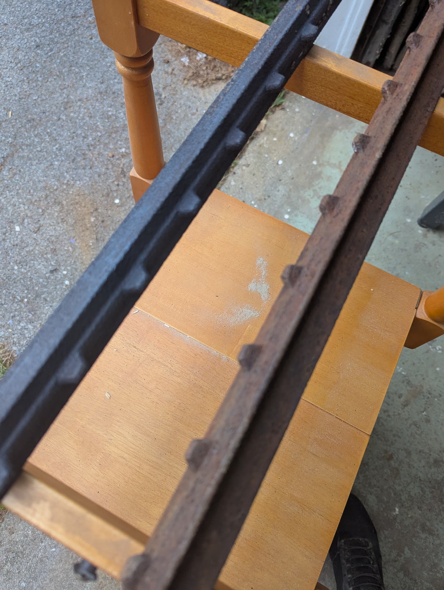 Two metal bars, one still rusted and one cleaned by laser