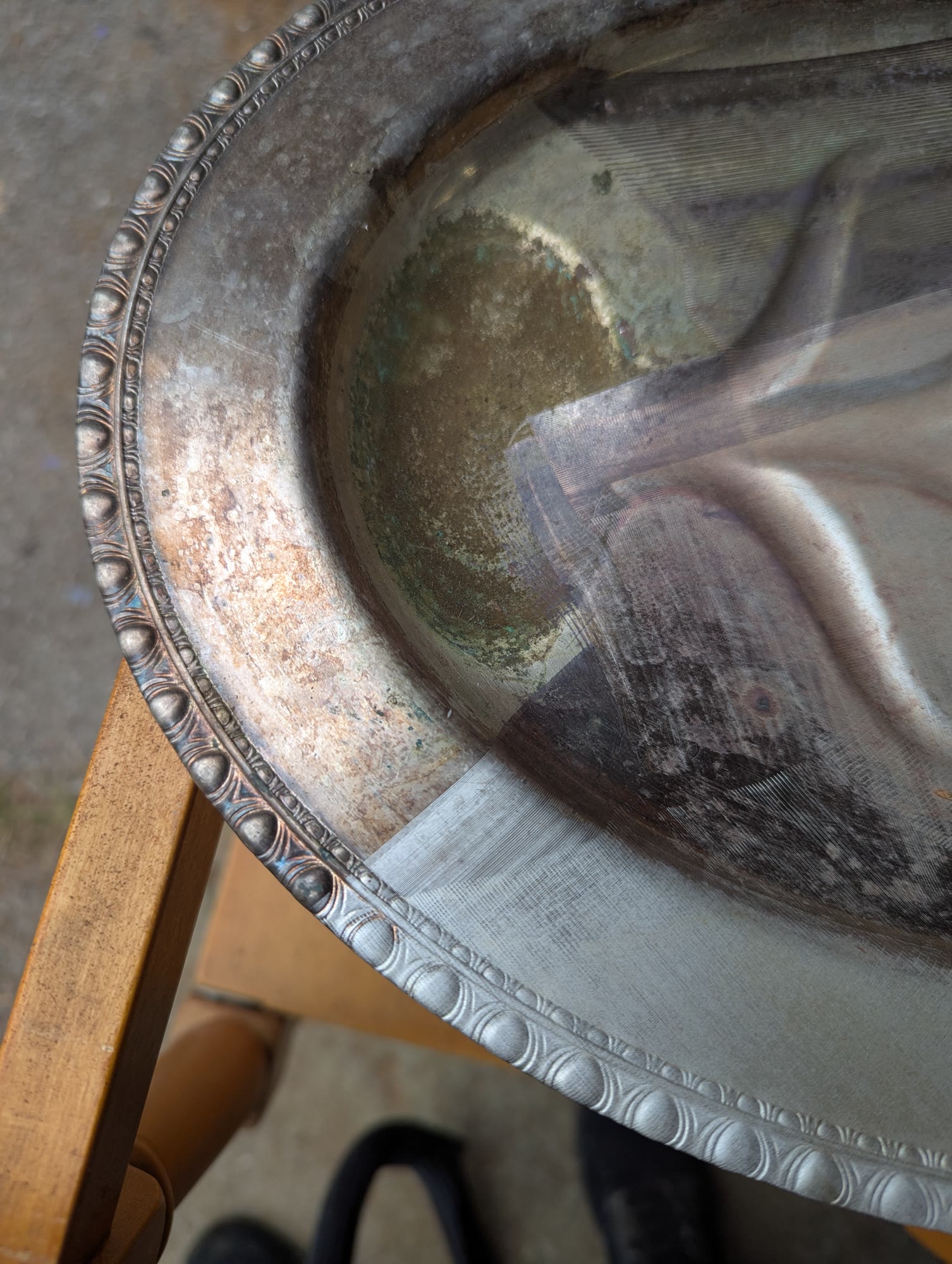 Silver platter with tarnish on the left and laser-cleaned metal on the right
